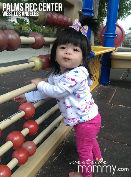 Aria playing with the giant abacus at the playground